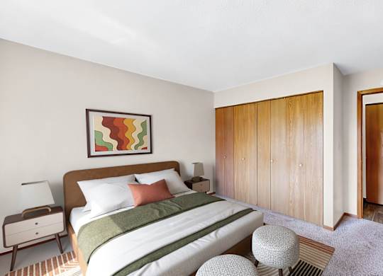 A bedroom with a bed, nightstand, and wardrobe.