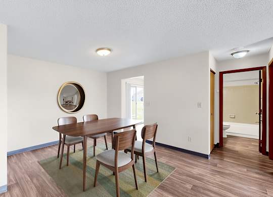 A dining room with a table and chairs.