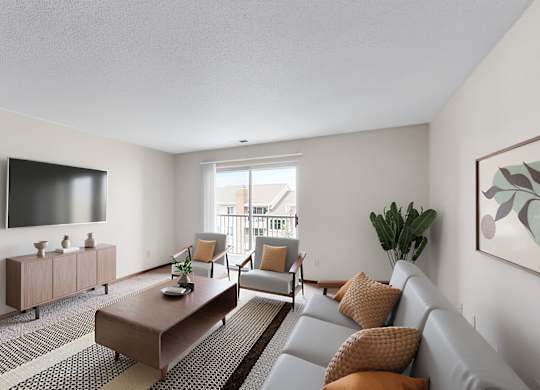 A living room with a grey couch, a brown coffee table, and a flat screen TV mounted on the wall.