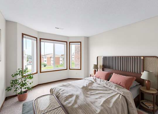 A bedroom with a large bed and a potted plant.