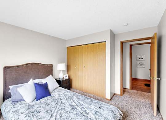 A bedroom with a bed, nightstand, and lamp.