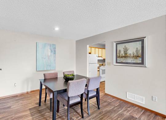 A dining room with a wooden table and chairs.