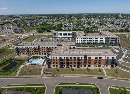 A large multi-story building with a pool in the front yard.
