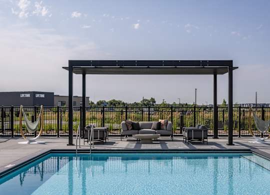 A pool with a hammock and a canopy.