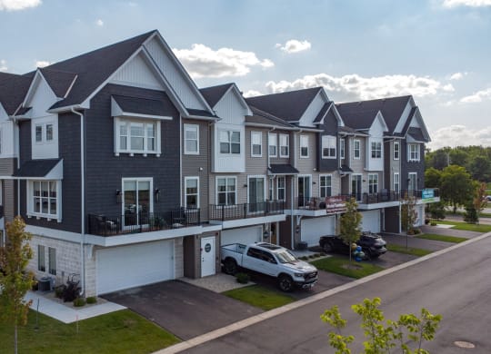 a row of townhouses with cars parked in front of them