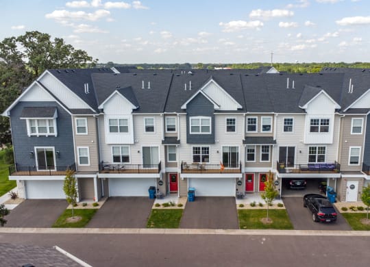 an aerial view of a townhome community with cars parked in front of it