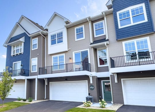 the exterior of a townhouse with two garage doors