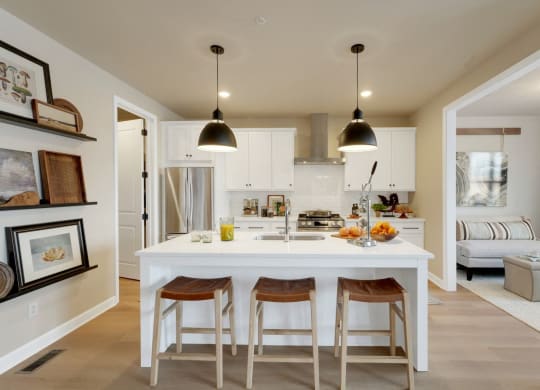 a kitchen with a white island and three stools