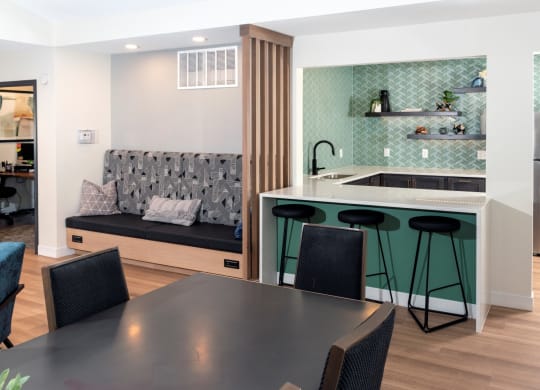 a kitchen with a black dining table and four black chairs