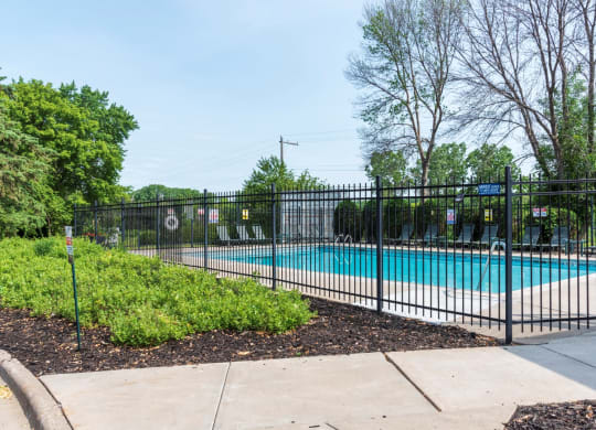 a swimming pool with a black fence in front of it