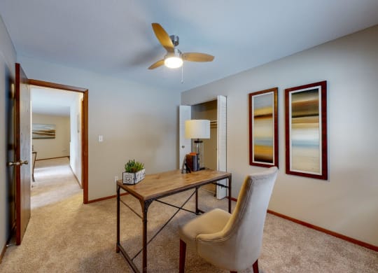 a desk with a chair and a lamp in a room