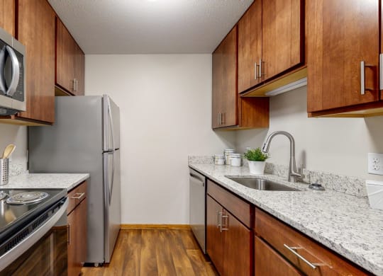 a kitchen with wooden cabinets and stainless steel appliances