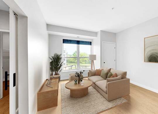 A living room with a couch, a coffee table, and a painting on the wall.