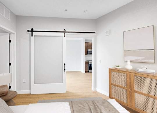 A bedroom with a bed, nightstand, and sliding door.