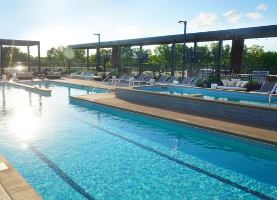 a resort style pool with lounge chairs and sun loungers