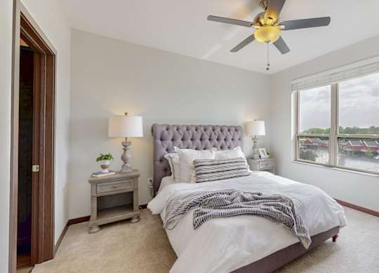 A bedroom with a large bed and a ceiling fan. at Lake Jonathan Flats, Chaska, MN, 55318