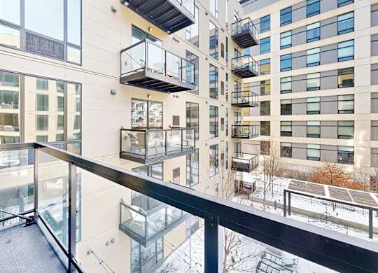 A modern building with balconies and glass railings.