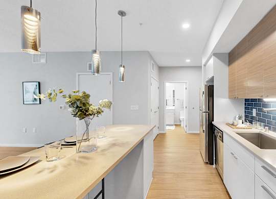 A modern kitchen with a long counter and a sink.