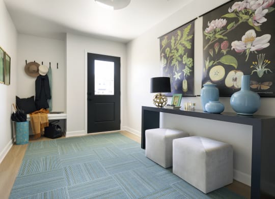 a living room with a blue rug and a black door
