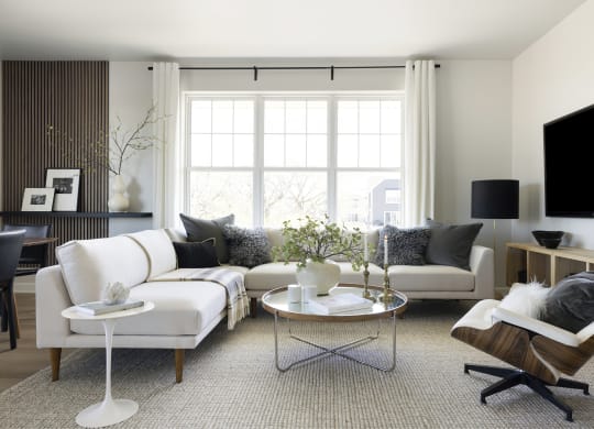 a living room with white furniture and a large window