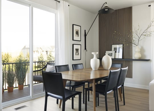 a dining room with a wooden table and black chairs