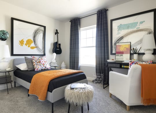 a bedroom with a bed and a chair and a desk