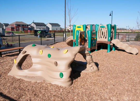 Playground Area with Wood-chips and Plastic Jungle Gym Sets at Carver Crossing Apartments