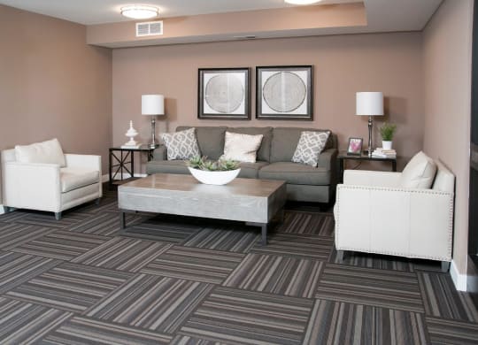 Carver Crossing Lobby with Large Grey Couch and Two White Leather Chairs