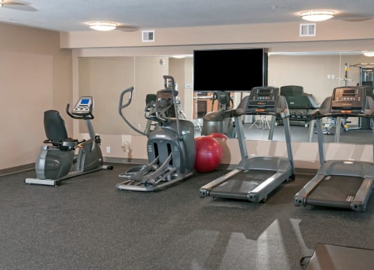 Fitness Room at Carver Crossing with Wall Length Mirrors and Flat Screen Television
