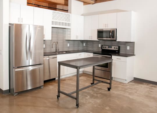 Kitchen with White Cabinetry, Stainless Steal Appliances and Movable Island at 700 Central Apartments, MN, 55414