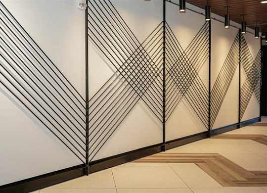 A wall with a black and white geometric design at The Bessemer at Seward Commons Apartments, MN, 55404