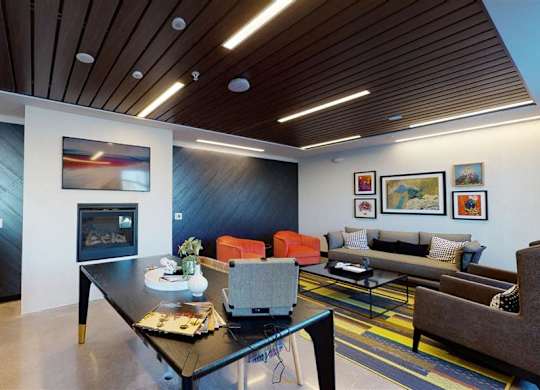 A modern living room with a fireplace and a couch at The Bessemer at Seward Commons Apartments, Minneapolis, 55404
