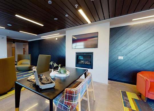 A modern dining room with a wooden table and chairs at The Bessemer at Seward Commons Apartments, Minnesota