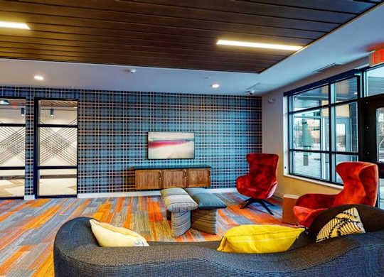 A room with a blue wall and a couch at The Bessemer at Seward Commons Apartments, Minneapolis, Minnesota