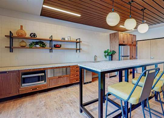 A kitchen with a table and chairs at The Bessemer at Seward Commons Apartments, Minnesota, 55404