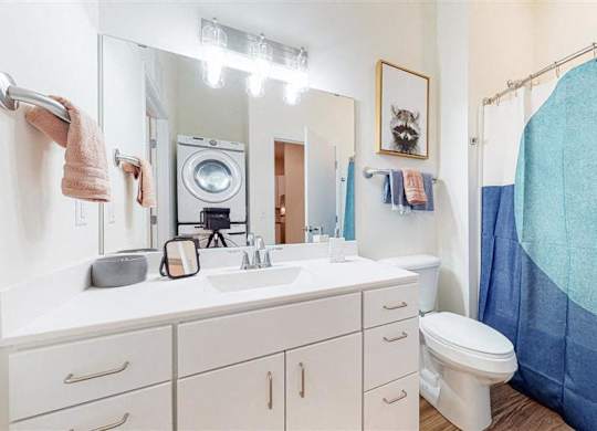 A bathroom with a white counter at The Bessemer at Seward Commons Apartments, Minnesota