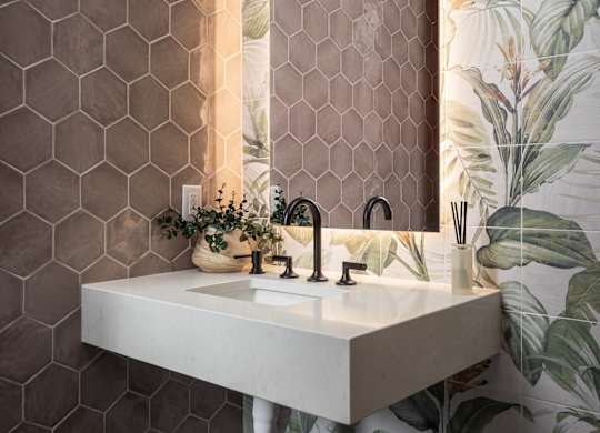 A bathroom with a white sink and a mirror with a wooden frame.