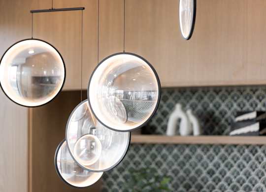 Four hanging lights are suspended from a wooden beam.