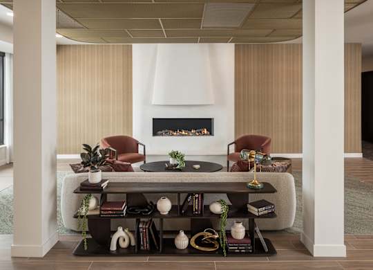 A living room with a fireplace and two chairs.