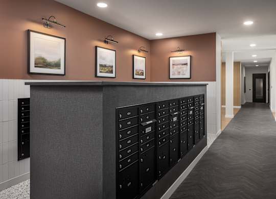A hallway with a row of mailboxes on the wall.