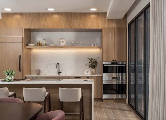 A modern kitchen with a wooden cabinet and a marble backsplash.