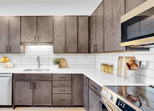 A kitchen with wooden cabinets and a white countertop.