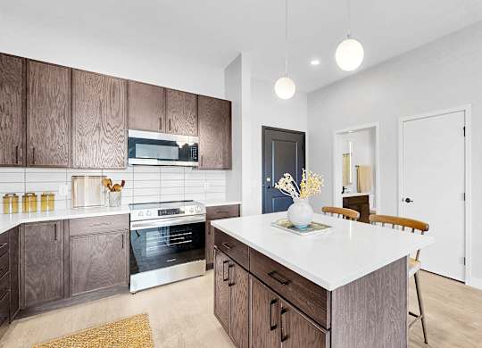A modern kitchen with a white island and wooden cabinets.
