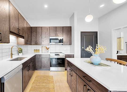 A modern kitchen with dark wood cabinets and white countertops.