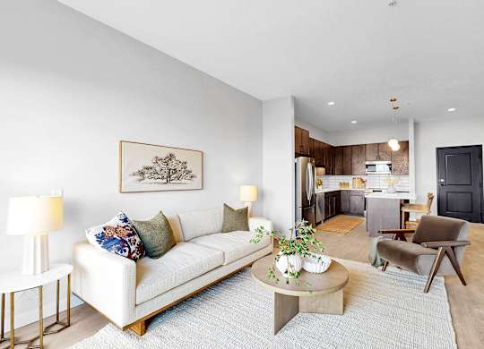 A living room with a white couch, a coffee table, and a painting on the wall.