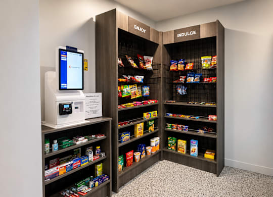 A modern vending machine is located in a room with a black and white checkered floor.