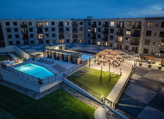 A large building with a pool and a lawn area.