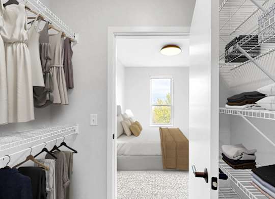 A white closet with clothes hanging and a doorway leading to a bedroom.