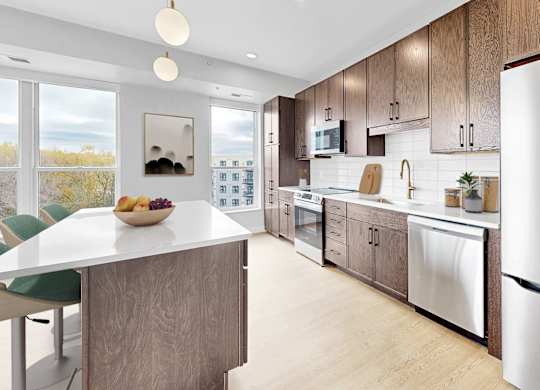 A modern kitchen with a large island and stainless steel appliances.