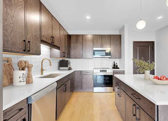 A modern kitchen with wooden cabinets and a white countertop.